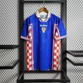 Retro Croatia 1998 away football shirt in blue with red and white checkered side panels, front view.